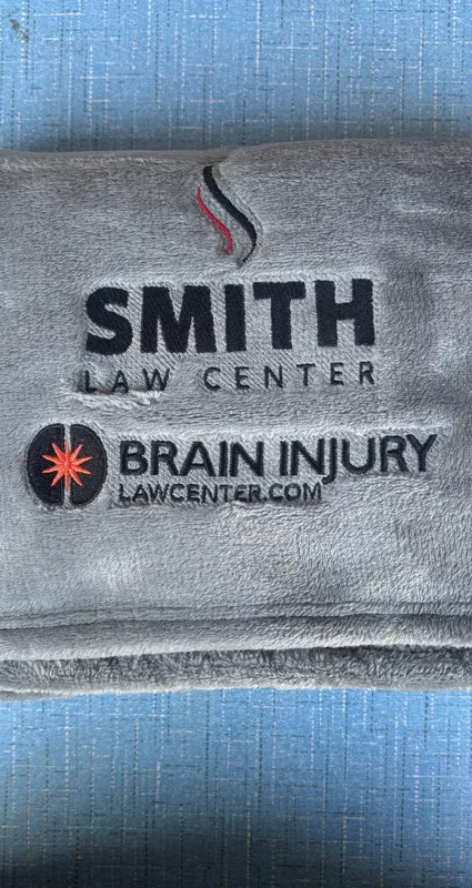 Smith Law Center logo embroidered on folded gray fleece blanket